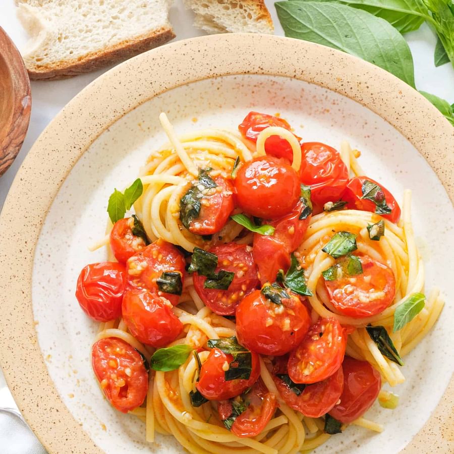Fresh Italian ingredients including ripe tomatoes, olive oil, cheese, and pasta